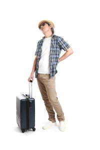 The senior Asian man standing with luggage on the white background.
