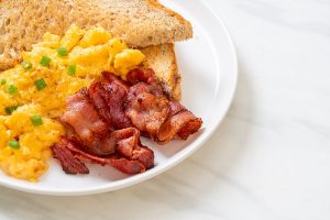 scrambled egg with bread toasted and bacon for breakfast